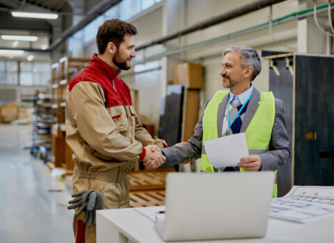 A contractor shaking hands with his wood supplier.