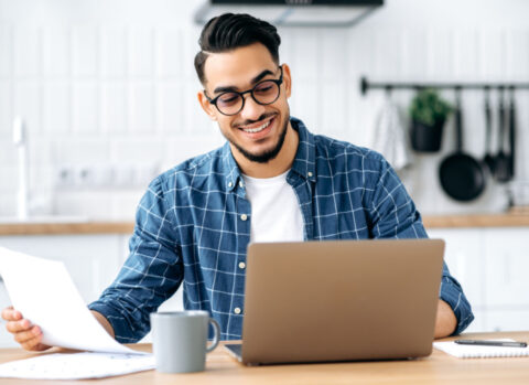 A man working out of his kitchen reviews a cash flow statement for his small business.