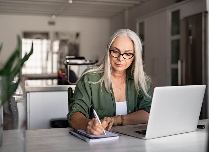 A small business owner using a laptop to send ACH payments to her vendors.