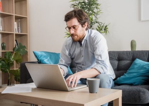A small business owner filling out a balance sheet on a laptop.
