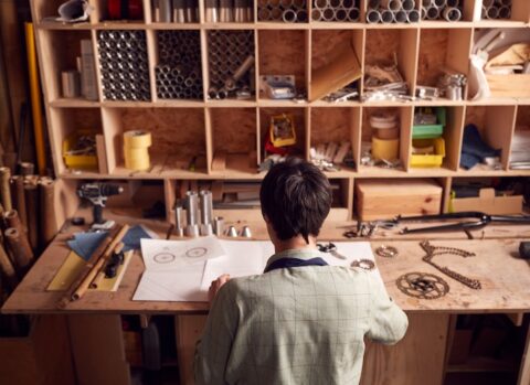 A business owner in his workshop feeling stressed and burnt out.