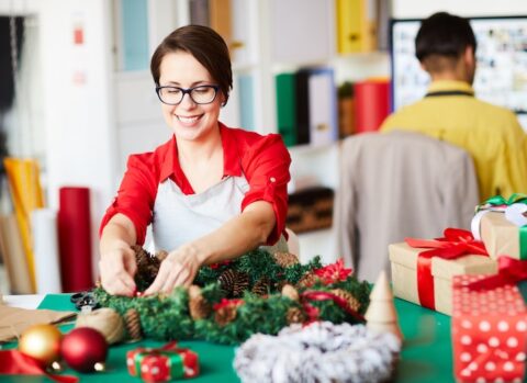 A small business owner setting up holiday decorations.