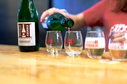 Talia pouring Haykin Family Cider into glasses.