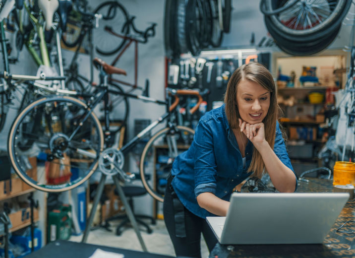 A small business owner sending a wire transfer online in her bike shop.