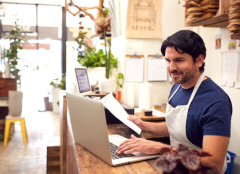 A small business owner approving invoices in his shop.