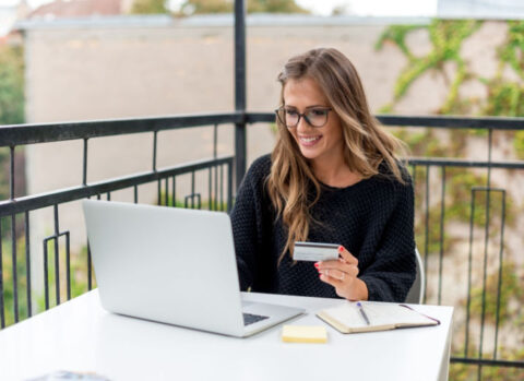 A small business owner using a laptop to pay her credit card balance online.