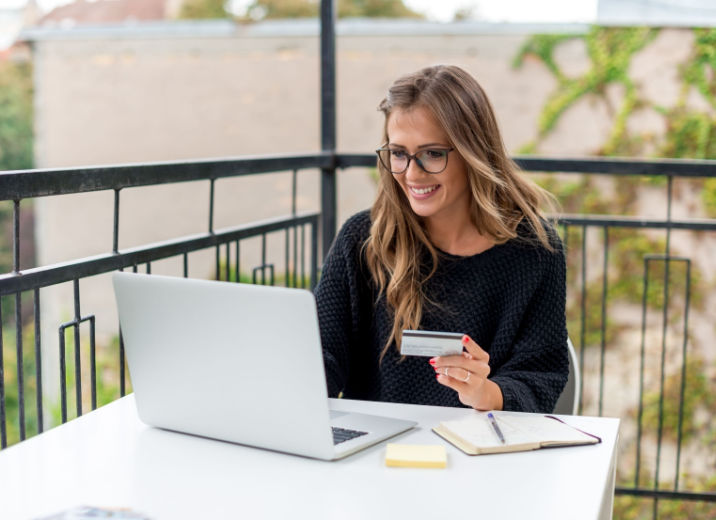 A small business owner using a laptop to pay her credit card balance online.