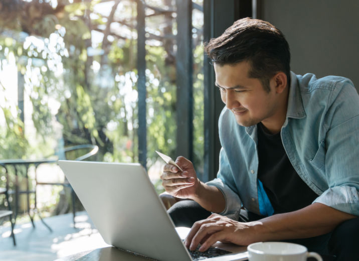 A small business owner using a laptop to pay bills online with a credit card.
