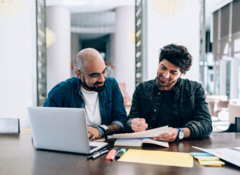 Two business partners reviewing the financial reports for their small business.