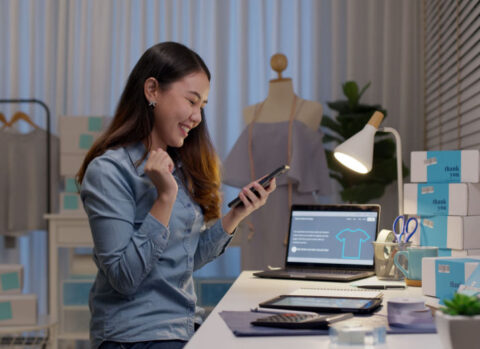 An e-commerce merchant using a mobile phone and online tools to improve her cash flow.