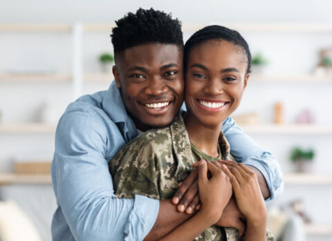 A soldier embraced by her spouse.