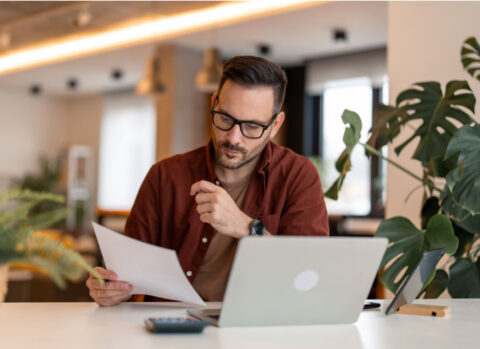 A small business owner handling B2B payments on his laptop.