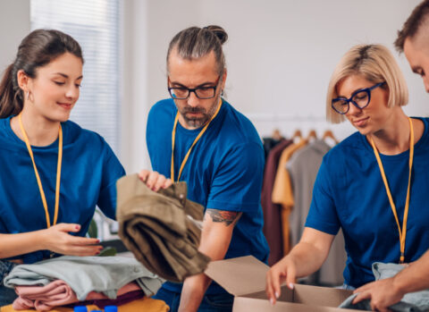 A group of volunteers at a nonprofit sorting out donations.