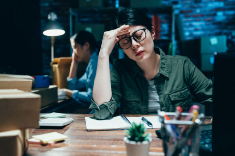 A small business owner appears stressed as she handles her finances.