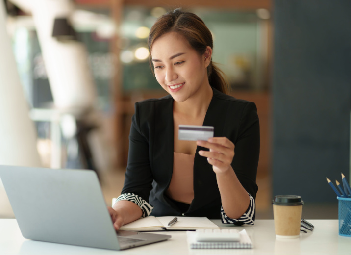 A small business owner using a laptop to pay her bills online with a credit card.