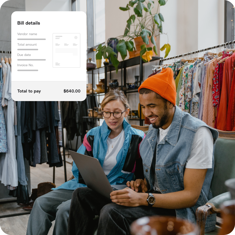 Two business owners looking at bill details, which automatically sync to Melio.