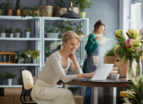 A florist using a laptop to pay multiple bills at once.