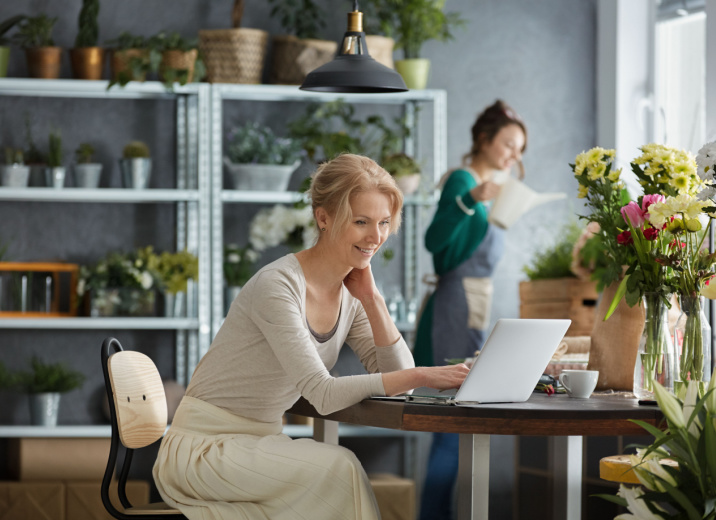 A florist using a laptop to pay multiple bills at once.