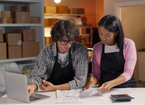 The owners of a small business reviewing the books together to come up with a pricing plan.