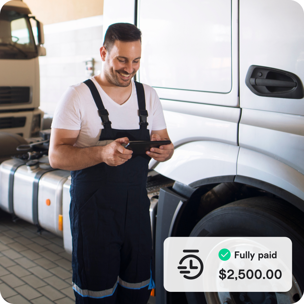 A small business owner with a tablet and truck in the background