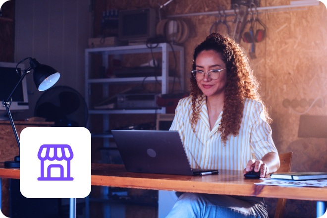 A female business owner working on a laptop in her home office.